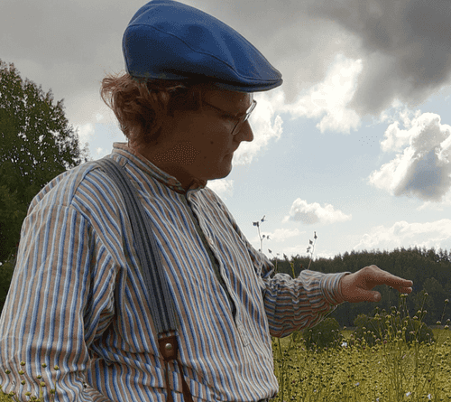 Man in a field wearing a hat.