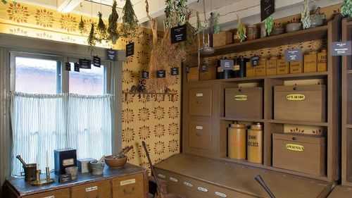 Herbs hanging from the ceiling, old medicine boxes.