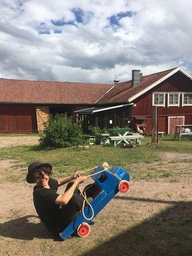  A child is playing with a wooden car.