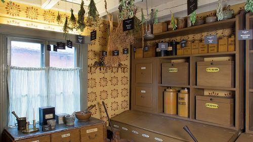 Herbs hanging from the ceiling, old medicine boxes.